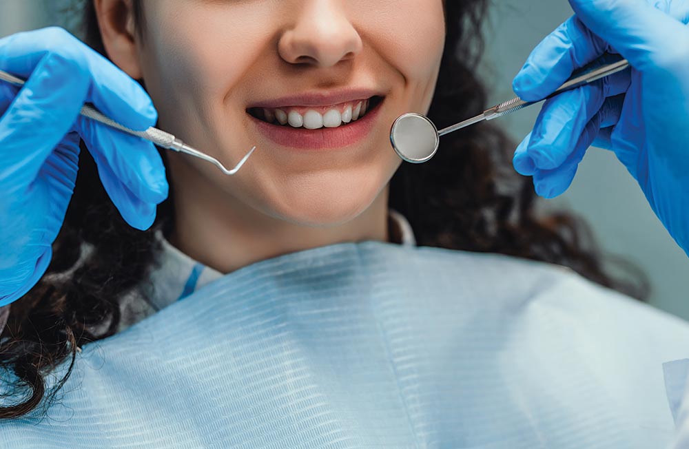 A girl getting a dental exam smiles