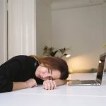 A young woman fallen asleep while studying at her computer